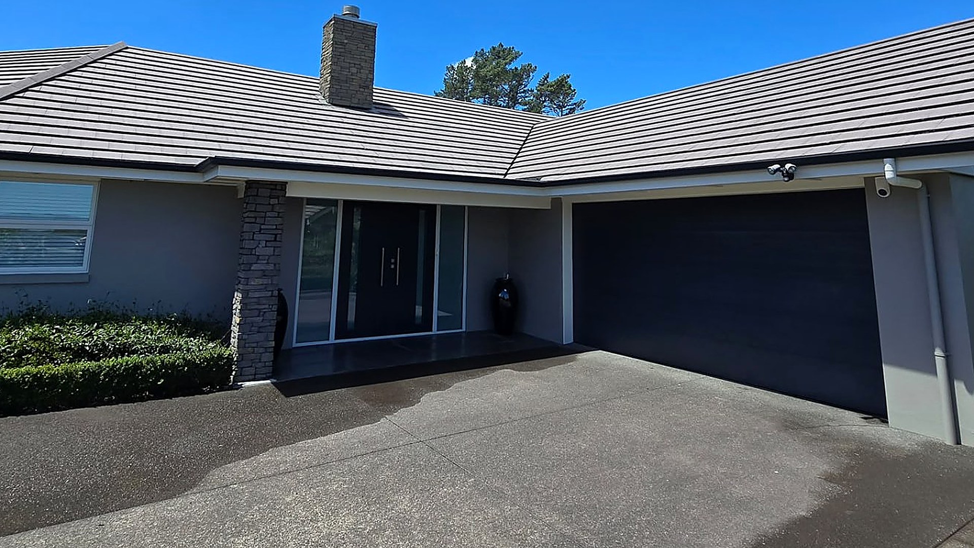 Roofline gutter and downpipes on an Auckland home against a clear sky